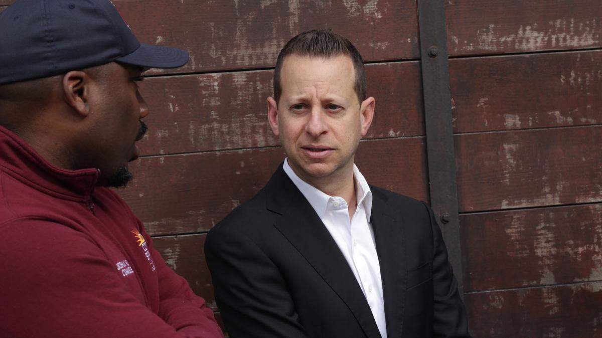 Jared Moskowitz, a U.S. representative for Florida’s 23rd congressional district, speaks with Commissioner Joshua Simmons after the official opening of the cattle car exhibit.