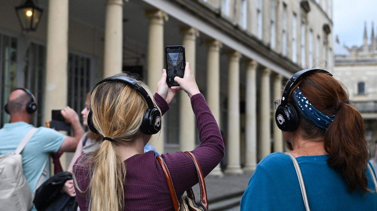 Visitors taking photographs with their mobile phones as they attend a visit to discover the sets of the Netflix series “Bridgerton”, in Bath, western England.