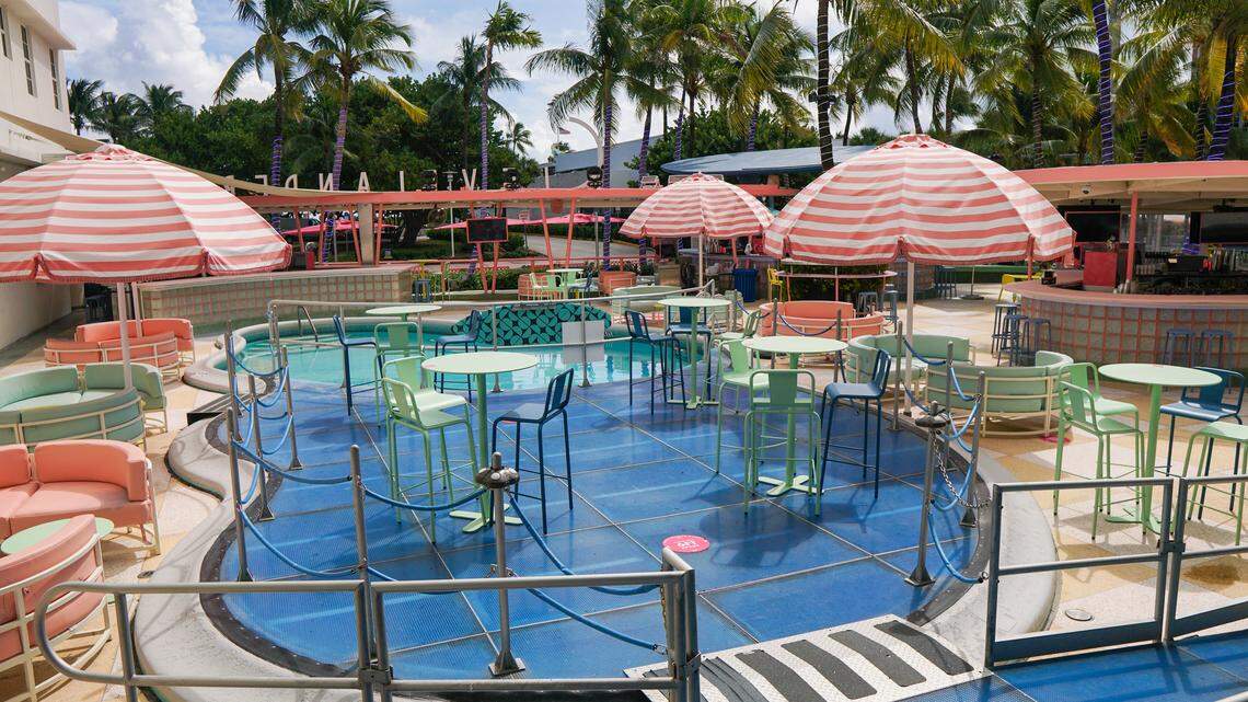 Dining tables and chairs with umbrellas on an outdoor poot deck.