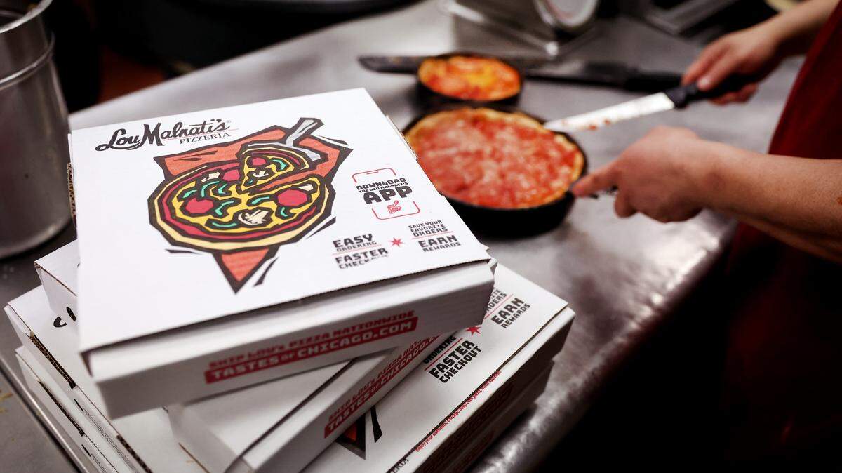 A worker prepares a Chicago-style deep dish pizza at a Lou Malnati’s restaurant in Chicago, Illinois.
