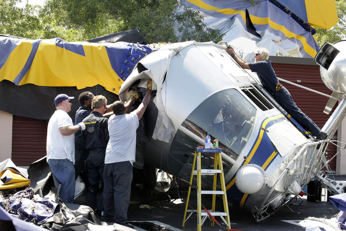 Workers cut swaths of the shell of the Goodyear blimp Stars & Stripes at Coral Springs Mini Storage the day after it crashed.