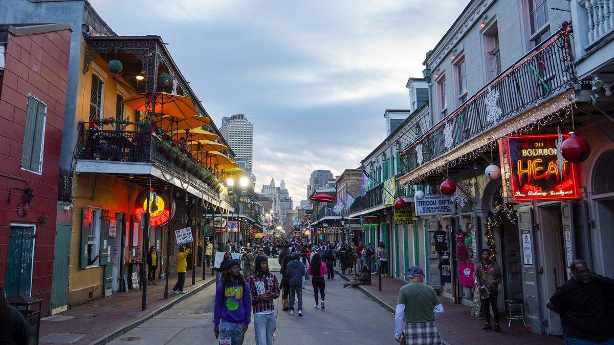 People walk on Bourbon Street in New Orleans, Louisiana.