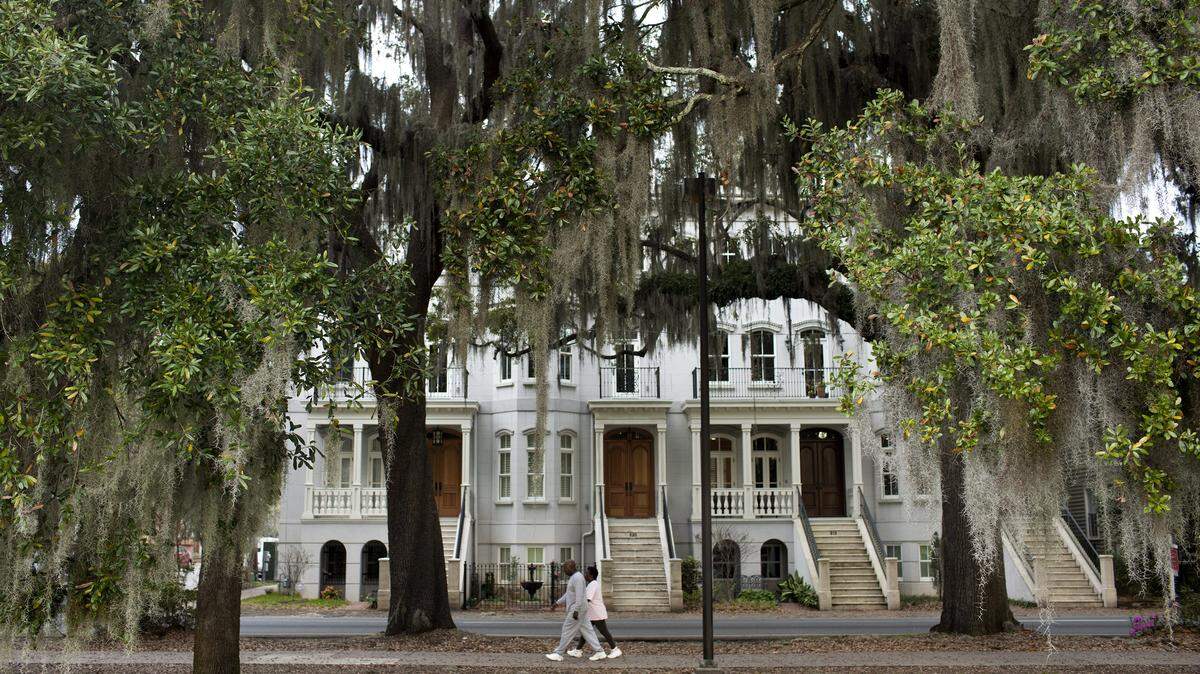 A couple walks along Forsyth Park in Savannah, Georgia.