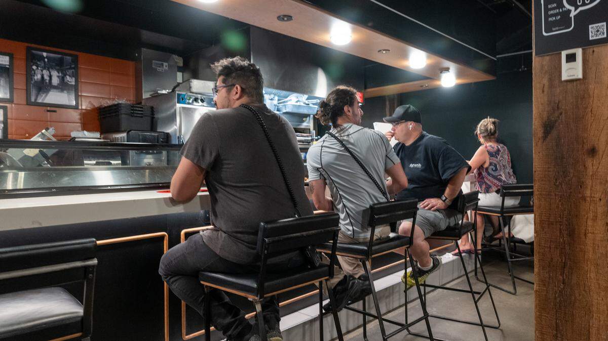 People dine at the counter of a food court.