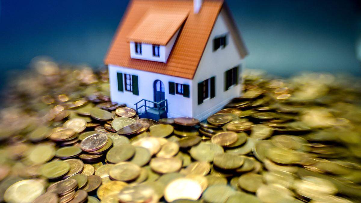 A model of house surrounded by coins.