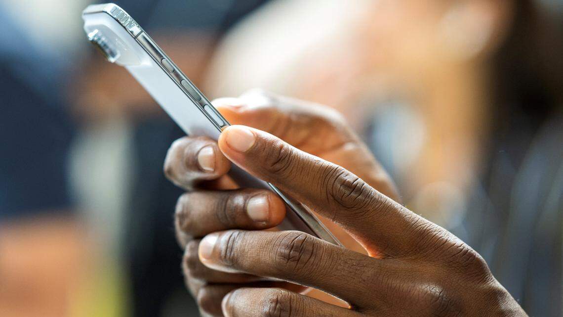 A person holds an Apple iPhone Air with two hands.