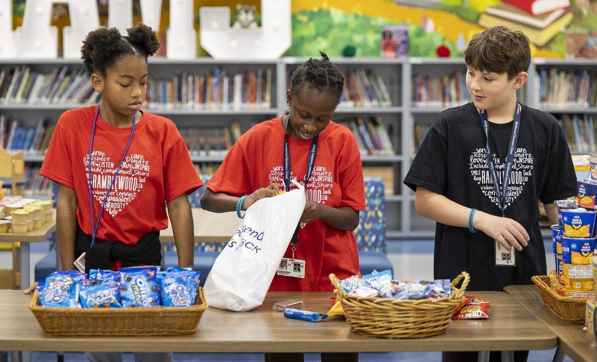 From left to right: Fifth graders Laniya Wynter, 10, Kylie Louis, 11, and Carson Dunn, 10, prepare “Weekend Packs” for children in need as Ramblewood Elementary School participates in a day of commemoration honoring the victims of the Marjory Stoneman Douglas High School tragedy on Friday, Feb. 13, in Coral Springs.