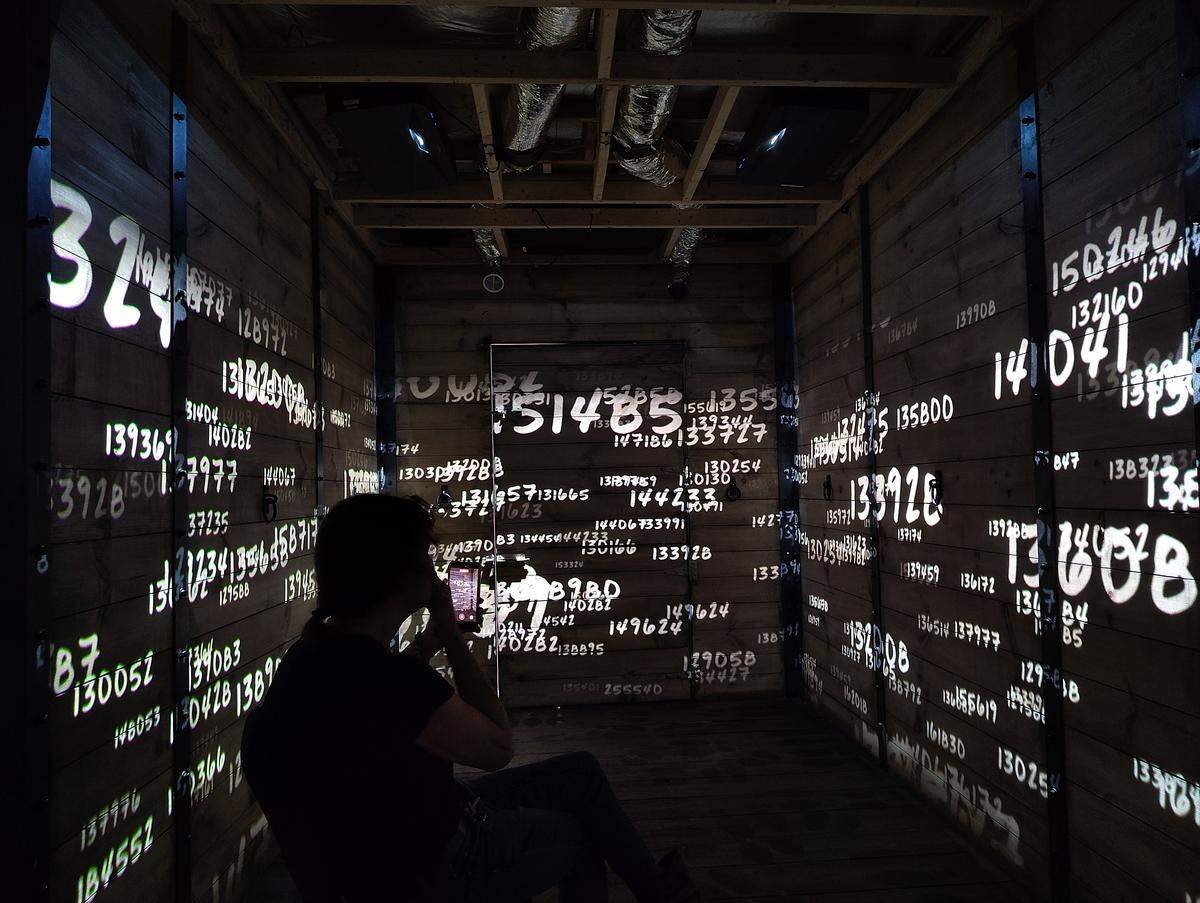 Amy Gilson watches as the experience’s narrator explains how those in concentration camps were assigned numbers, rather than being referred to with their names.