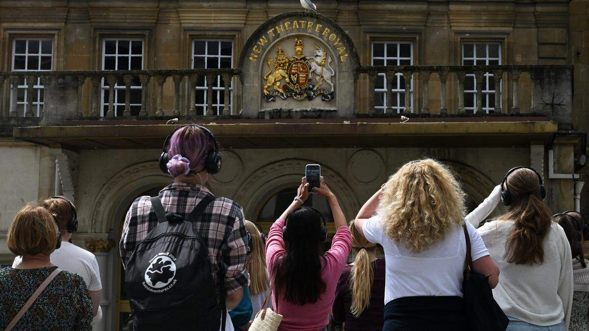 Visitors take photographs with their mobile phones as they attend a visit to discover the sets of the Netflix series “Bridgerton”, in Bath, western England.