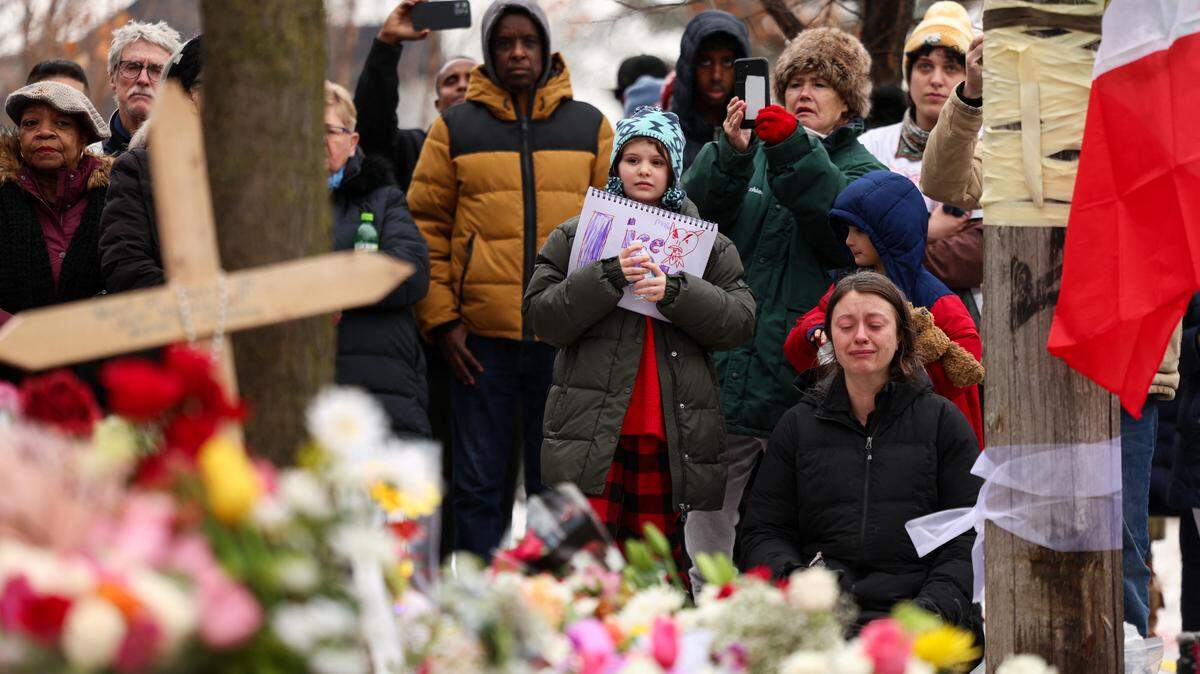 People gather at the street where 37-year-old Renee Nicole Good was shot and killed at point blank range on January 7 by a US Immigration and Customs Enforcement (ICE) agent in Minneapolis, Minnesota.