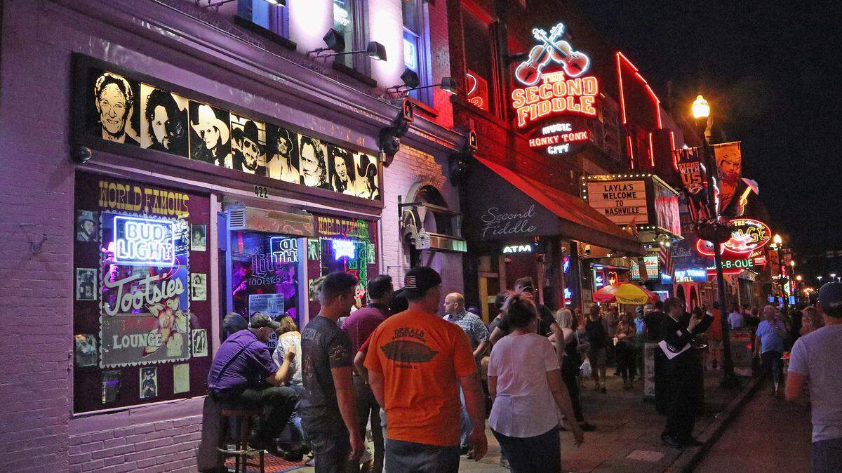 Tourists walk down Broadway in Nashville, Tennessee.