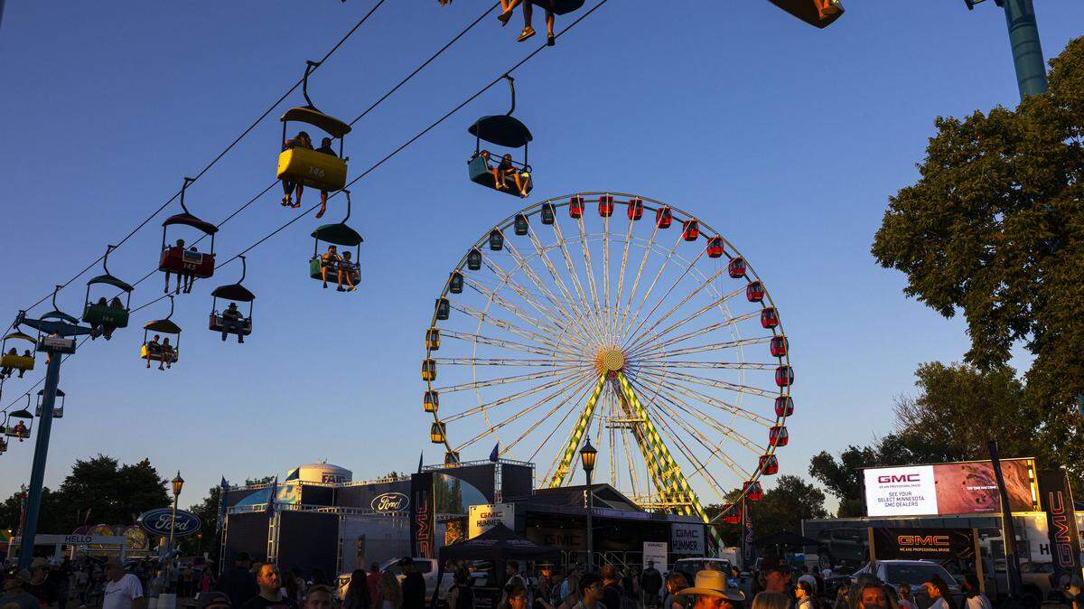 Fairgoers enjoy the Minnesota State Fair vendors and rides.