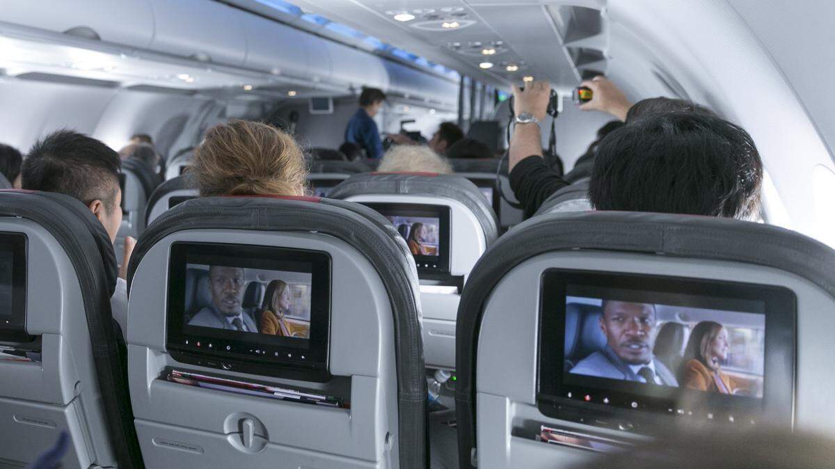 Passengers enjoying an in-flight movie on seaback screens.