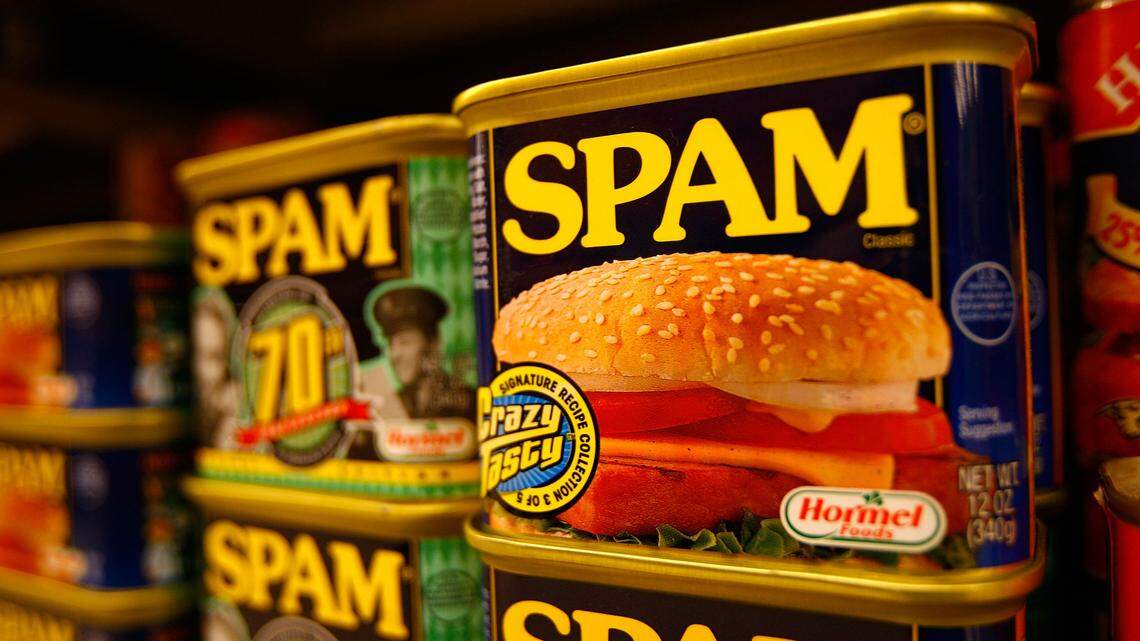 Cans of SPAM stacked on a shelf.