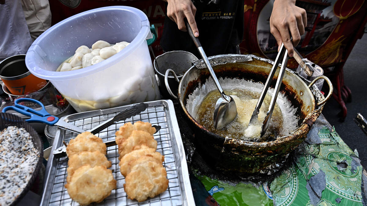 A street food vendor is preparing fried glutinous rice cakes in Chinatown in Bangkok.