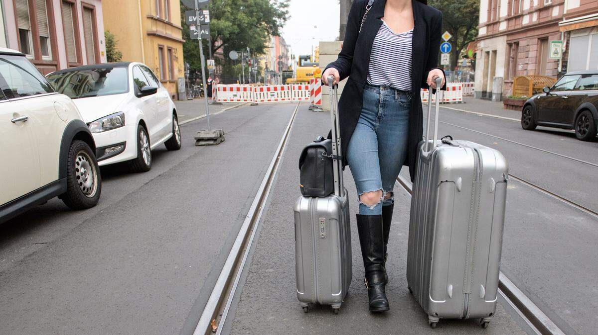 A woman pulls suitcases as she leaves her appartment in Frankfurt am Main, western Germany.