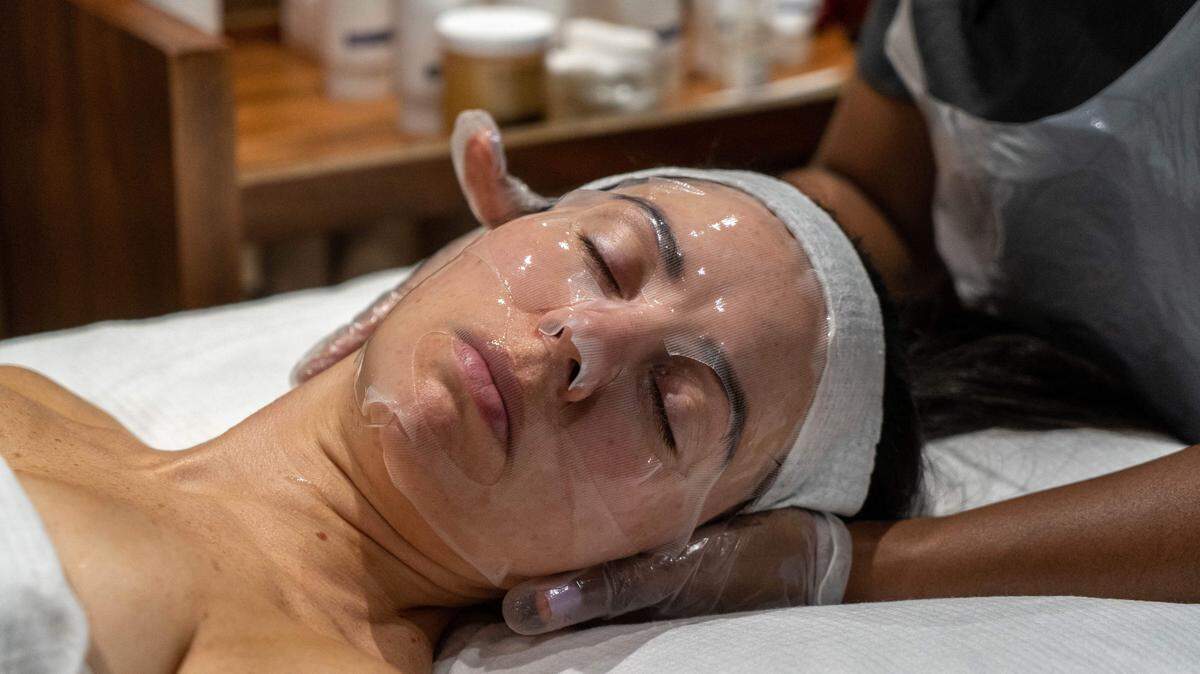 A woman recieves a facial treatment and massage.