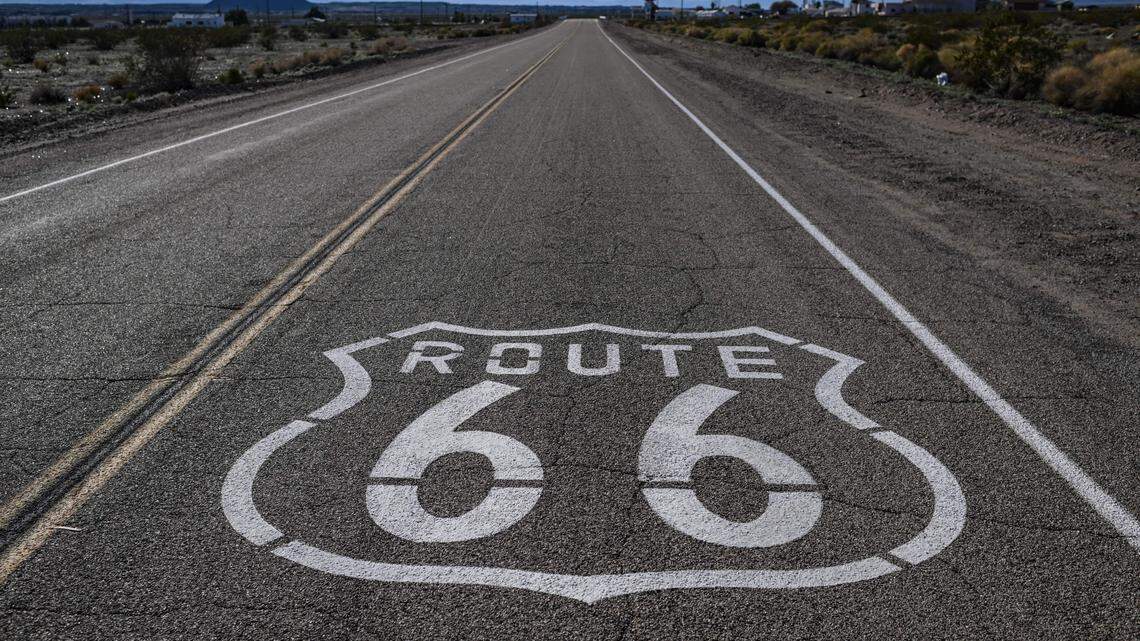 A “Route 66” sign is painted on the asphalt road.