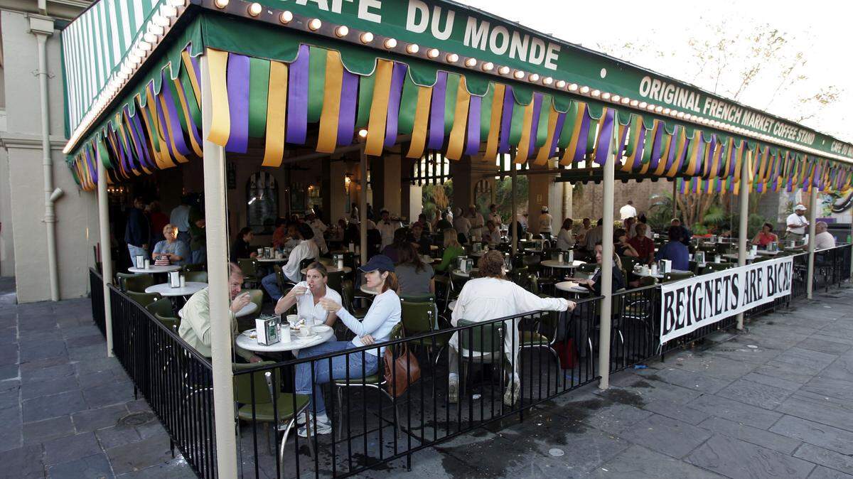 Patrons enjoy orders of coffee and chicory and beignets at Cafe Du Monde in New Orleans, Louisiana.