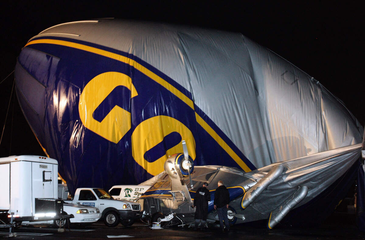 A Goodyear blimp, Stars & Stripes, sits on a building after it crash-landed in an industrial park in Coral Springs, Florida, Thursday, June 16, 2005. The two people aboard were trapped inside while electrical crews cleared the site, authorities said, but no one was injured.