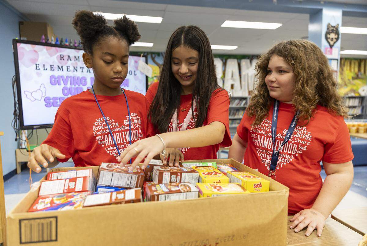 From left to right: fifth graders Laniya Wynter, 10, Sofia Peña, 11, and Molly Hochhauser, 10, prepare “Weekend Packs” for children in need as Ramblewood Elementary School participates in a day of commemoration honoring the victims of the Marjory Stoneman Douglas High School tragedy on Friday, Feb. 13, in Coral Springs.
