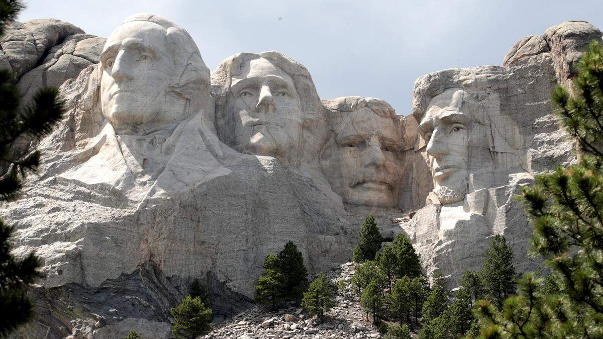 The busts of U.S. presidents George Washington, Thomas Jefferson, Theodore Roosevelt and Abraham Lincoln tower over the Black Hills at Mount Rushmore National Monument.