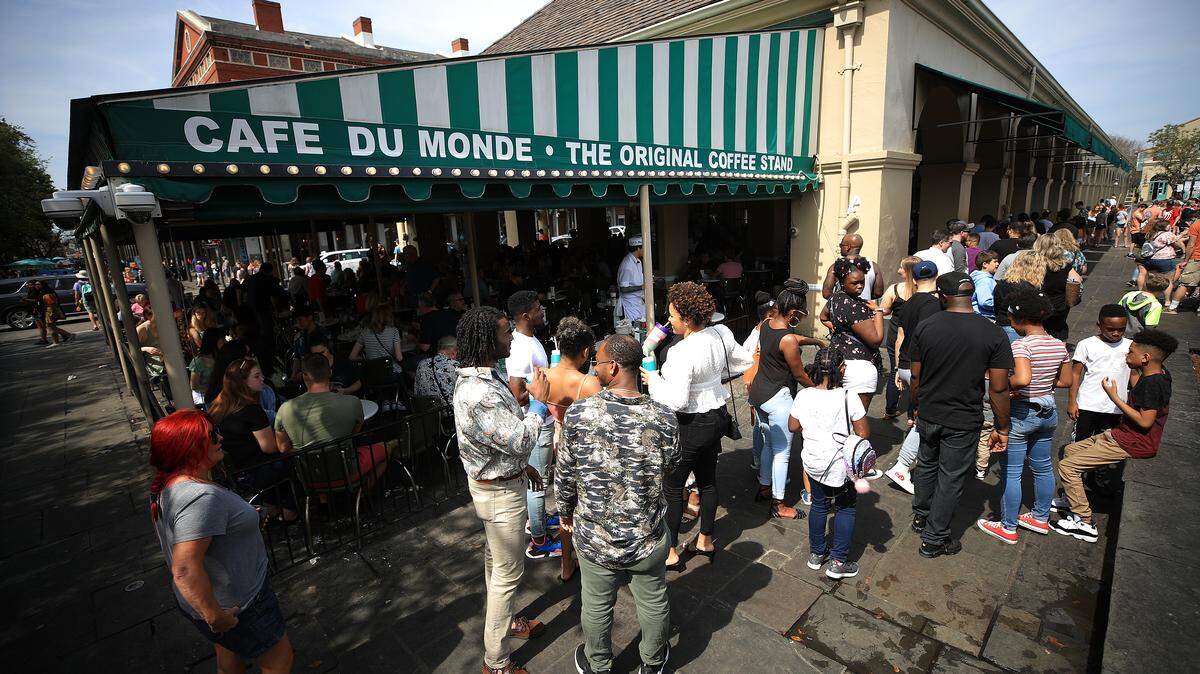 A large crowd gathers at Cafe Du Monde in the French Quarter in New Orleans, Louisiana.
