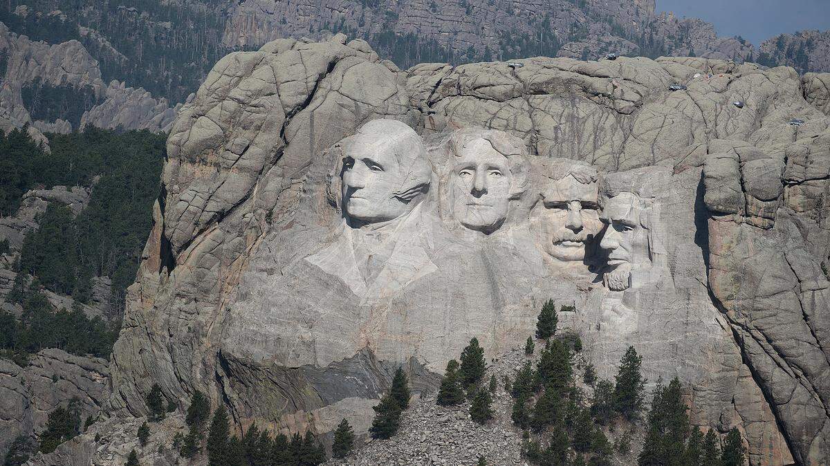The busts of U.S. presidents George Washington, Thomas Jefferson, Theodore Roosevelt and Abraham Lincoln tower over the Black Hills at Mount Rushmore National Monument.