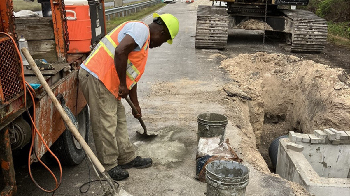 A construction worker installs drainage equipment west of University Drive in November 2023.