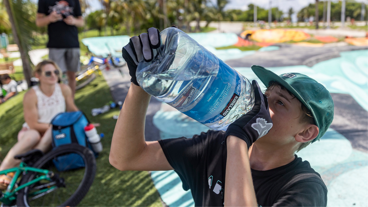 Aaron McElwain, 13, drinks some water after riding his scooter at Haulover Skateboard Park on Wednesday, June 14, 2023, in Miami Beach, Fla.