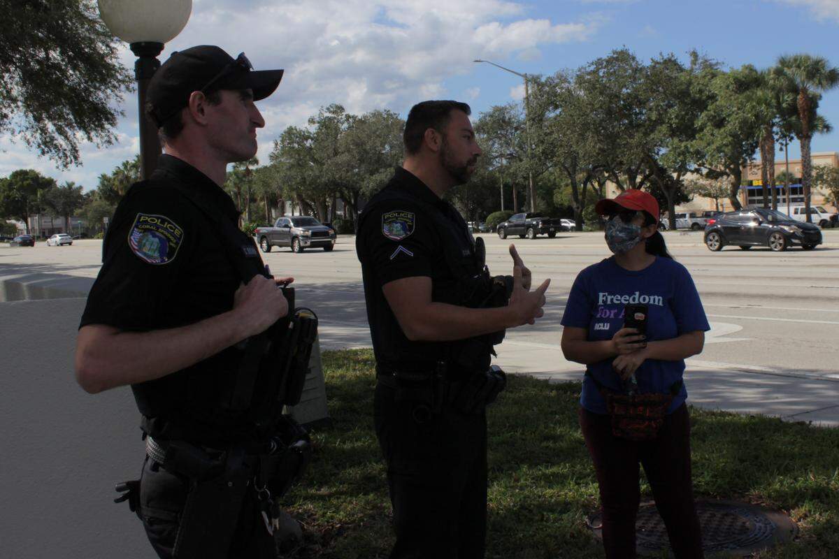Police stopped to speak with protesters and their legal observer, pictured on the right, on Saturday morning. They did not threaten any arrests.