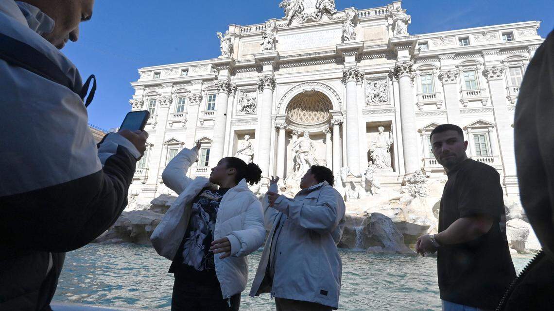 Visitors throw coins into the Trevi Fountain in Rome