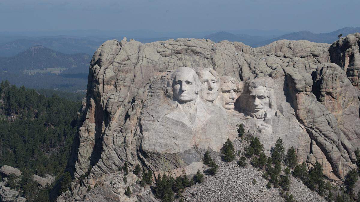The busts of U.S. presidents George Washington, Thomas Jefferson, Theodore Roosevelt and Abraham Lincoln tower over the Black Hills at Mount Rushmore National Monument.