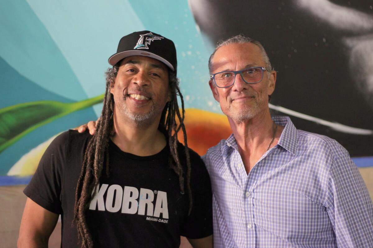 Ruben Ubiera, left, and Gary Rack pose in front of a partially completed mural in the soon-to-open Gary Rack’s Farmhouse Kitchen in downtown Coral Springs.