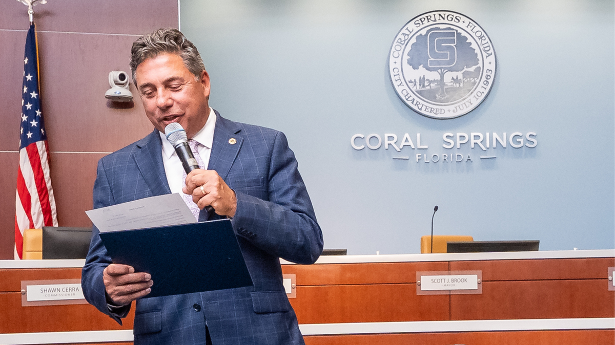 Coral Springs mayor Scott Brook reads a proclamation during the City Commission meeting on May 6, 2026.