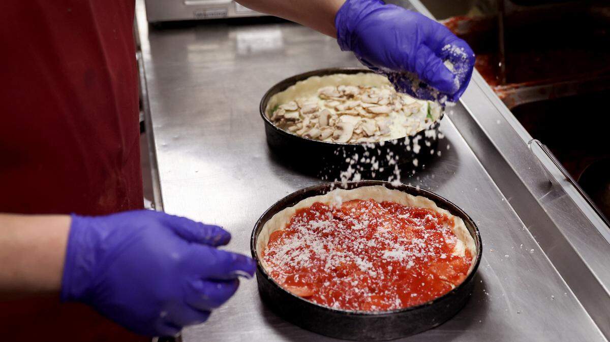 A worker prepares a Chicago-style deep dish pizza at a Lou Malnati’s restaurant in Chicago, Illinois.
