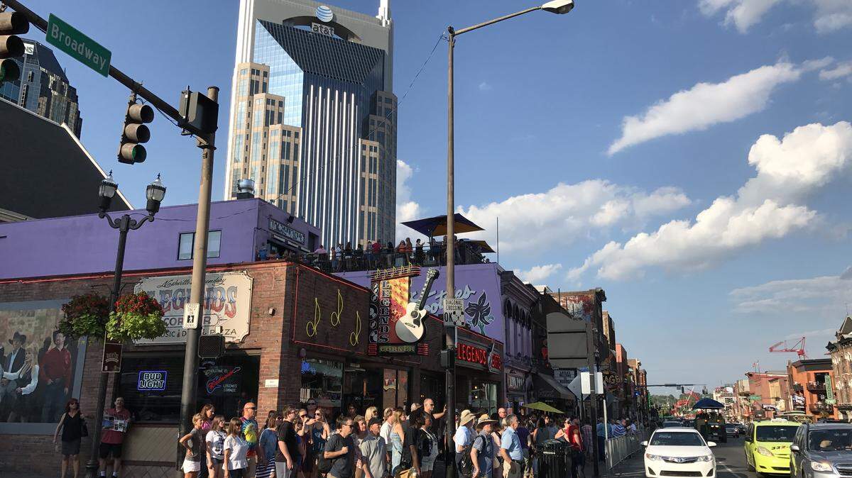 A crowd of people walk on Broadway in Nashville, Tennessee.