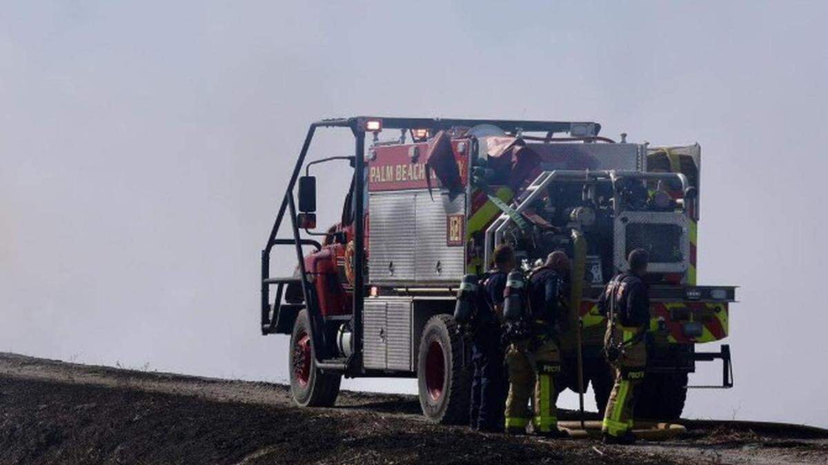 Surrounded by smoke-filled sky, a photo from Wednesday, Feb. 25, shows Palm Beach County Fire Rescue firefighters tackle a wildfire near Big Cypress National Reserve.