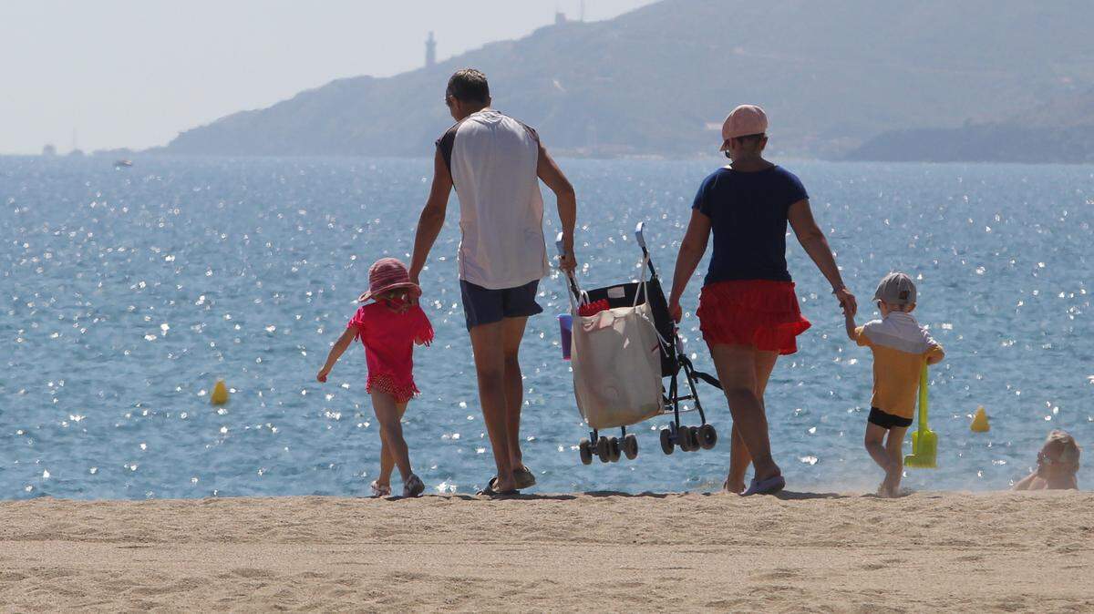 A family walks on the beach at Argeles-sur-Mer, southern France.