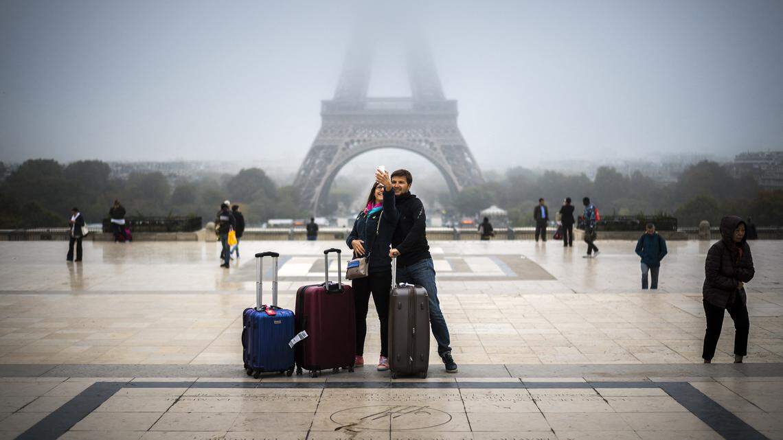 Tourists take a selfie on the Parvis des droits de l’homme square, in front of the Eiffel tower in Paris.