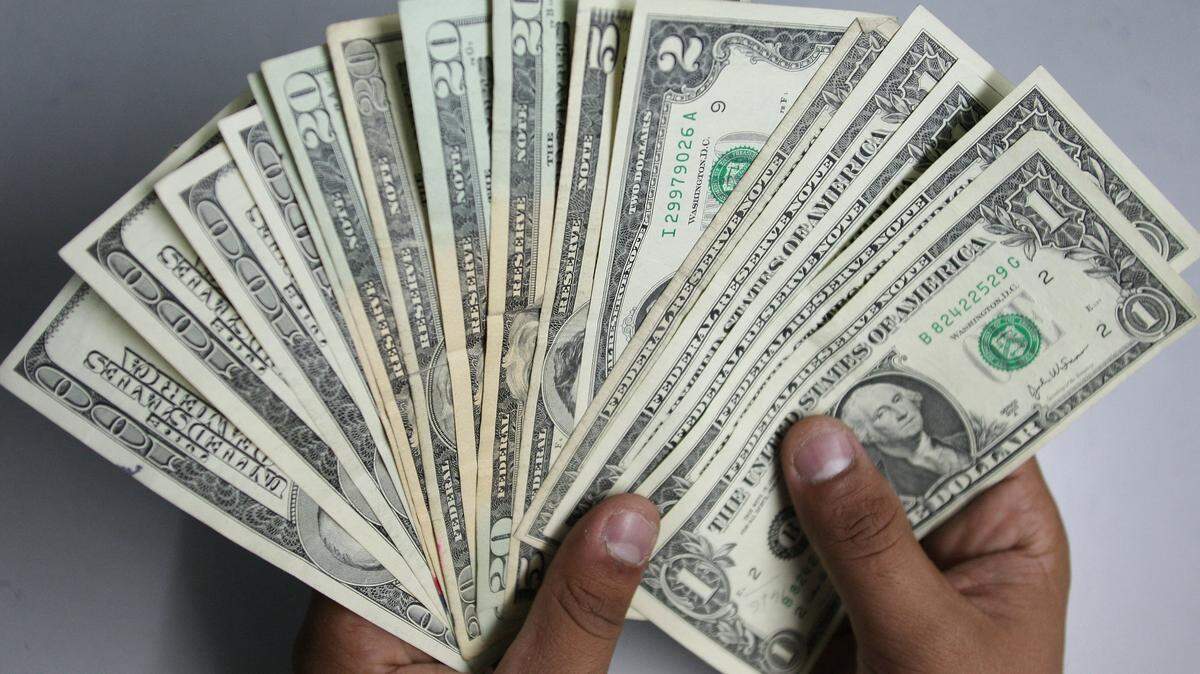Two hands holding a fanned out stack of US money.